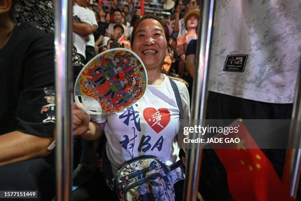 This photo taken on July 30, 2023 shows a basketball fan watching a third-place match of the grassroots basketball competition CunBA in Taipan...