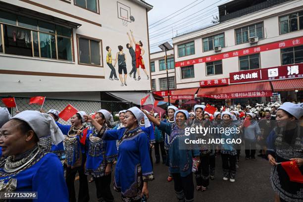 This photo taken on July 30, 2023 shows performers clad in Miao ethnic minority costumes arriving outside the stadium hosting games of the grassroots...