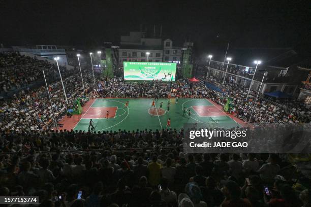 This photo taken late on July 30, 2023 shows a view of spectators watching a game of the grassroots basketball competition CunBA in Taipan village,...