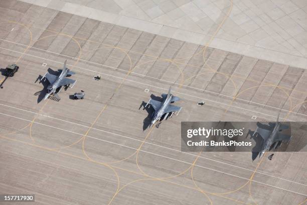 three f-16 fighter jets on tarmac ready for flight - militair vliegtuig stockfoto's en -beelden