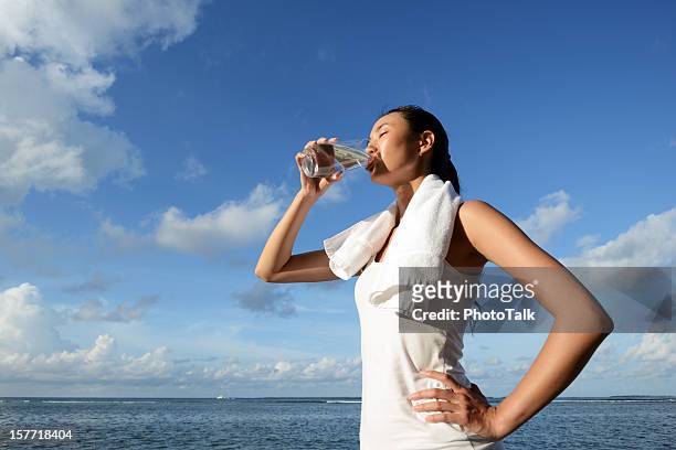 frau trinken wasser nach fitness - woman towel beach stock-fotos und bilder