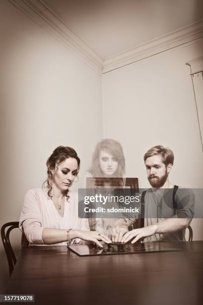 coppia di comunicare con spirito di giovane donna - seduta spiritica foto e immagini stock