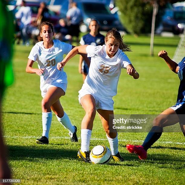 attractive female soccer players compete for control of ball - blocking sports activity stock pictures, royalty-free photos & images