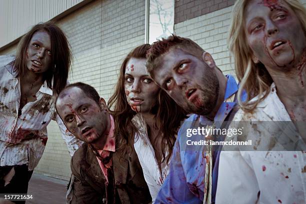 a group of adult zombies at a bus stop - zombie makeup stock pictures, royalty-free photos & images