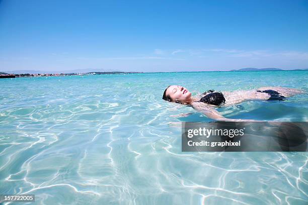 young woman lying in shallow tropical sea - whitehaven beach stockfoto's en -beelden