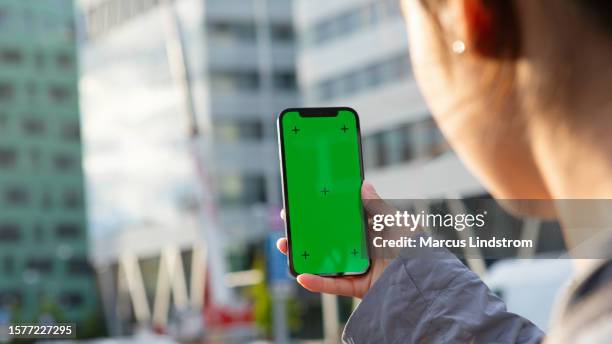 young woman using a mobile app in the city - green screen stock pictures, royalty-free photos & images