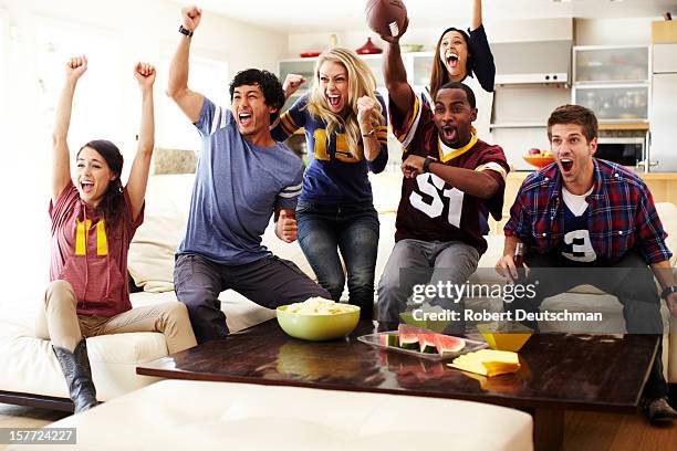 friends watching football in living room. - aficionado fotografías e imágenes de stock