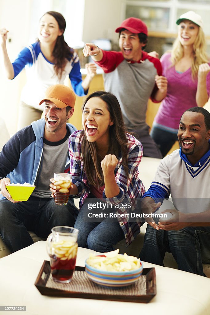 Friends watching baseball and cheering.