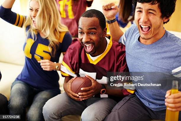 friends watching football in living room. - american football sport stock-fotos und bilder