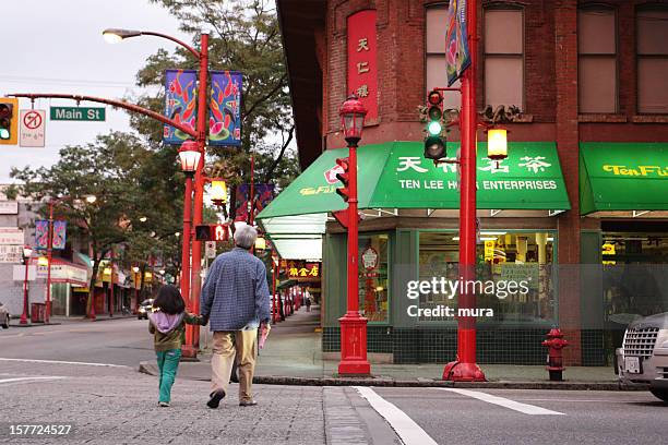 senior taking a child across the street - vancouver stock pictures, royalty-free photos & images