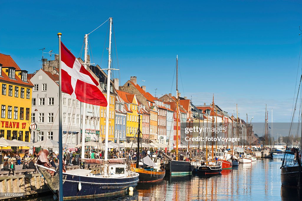 Copenhagen Danish flag flying over Nyhavn colourful harbour