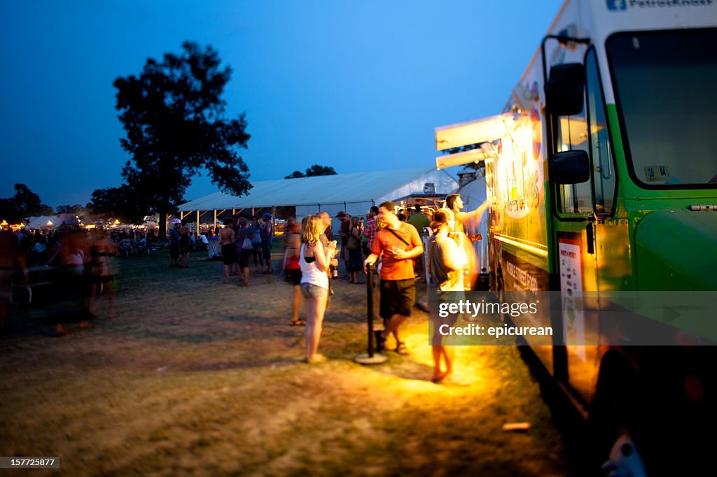 Festival goers getting dinner from a food truck