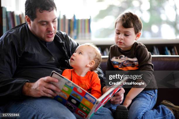 father and sons at the library - book worm stock pictures, royalty-free photos & images