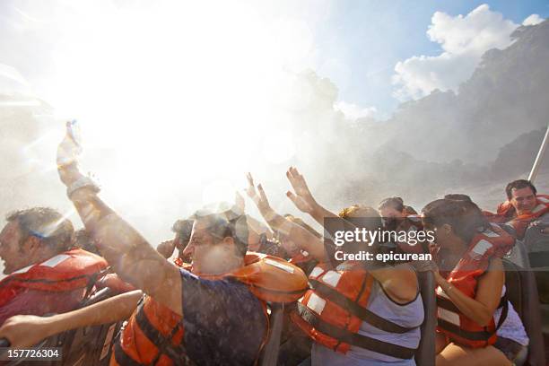 touristen in eine bootsfahrt in iguazu falls, argentinien - iguacufälle stock-fotos und bilder