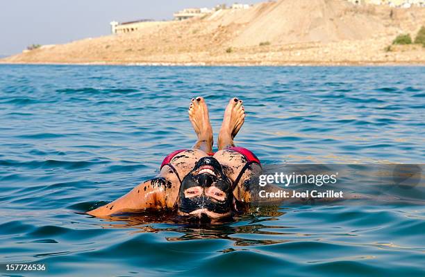 dead sea vacation with woman floating on back - dead sea stock pictures, royalty-free photos & images