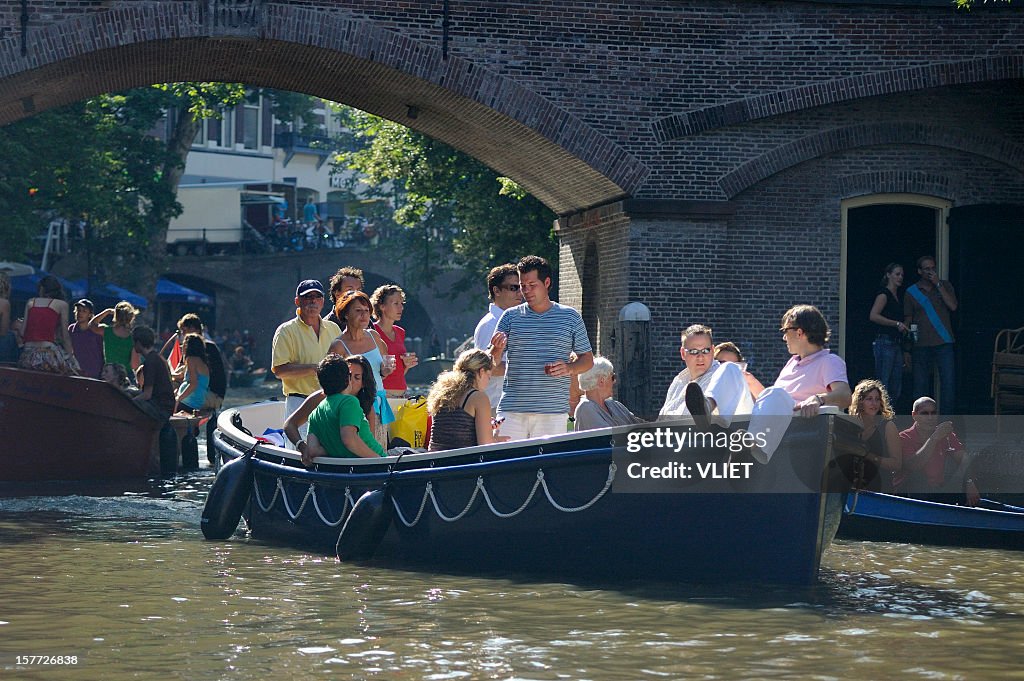People relaxing on recreational boats in the canal Oudegracht
