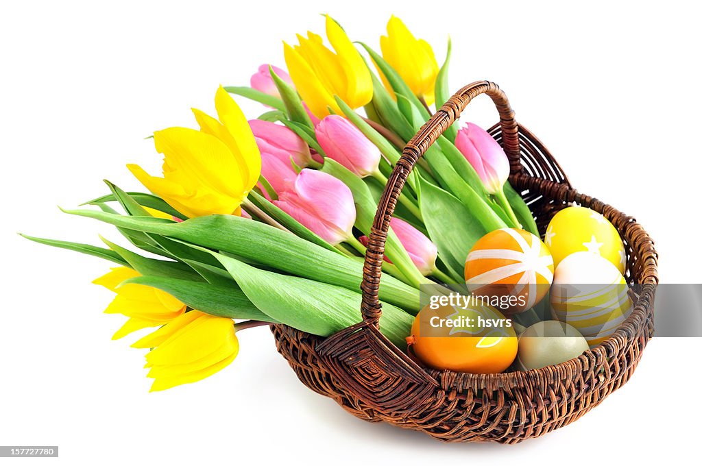 Basket with bunch pink yellow tulips and eggs white background