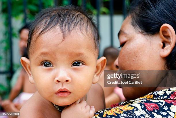 bebé espera al aire libre para la inoculación de camboya - países en vías de desarrollo fotografías e imágenes de stock