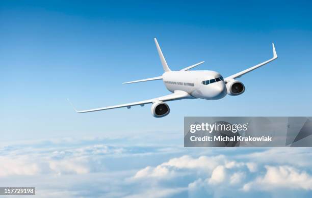 white passenger aircraft flying over clouds - aircraft wing stock pictures, royalty-free photos & images