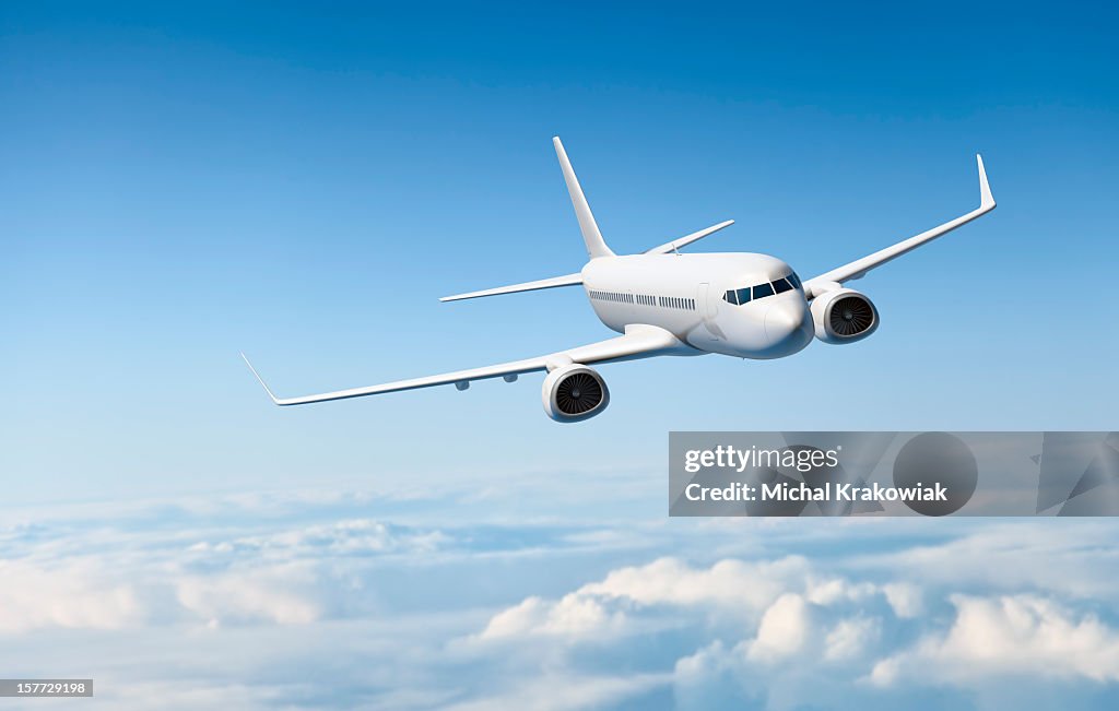White passenger aircraft flying over clouds