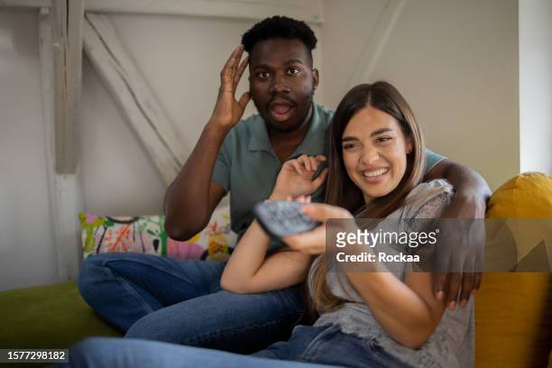 young couple watching tv - family in front of tv stock pictures, royalty-free photos & images