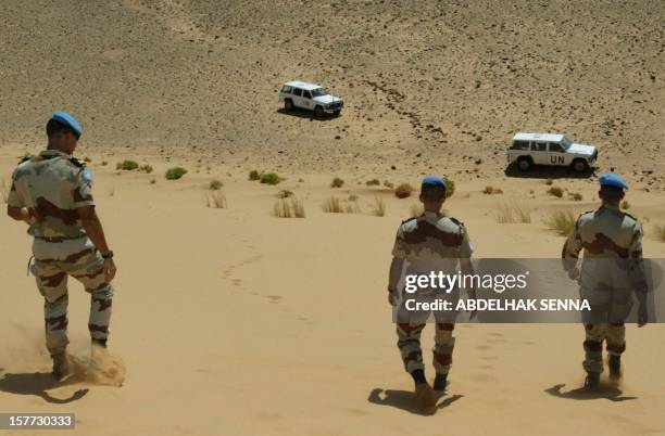 French soldiers of the United Nations mission for the organization of a referendum in Western Sahara walk in an almost desert landscape toward their...