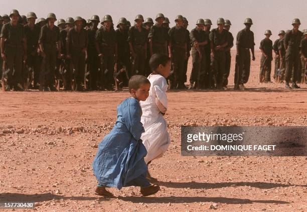 Sahrawi refugee children pass in front of a Polisario front detachment of soldiers before the welcoming ceremony of United Nations Secretary General...