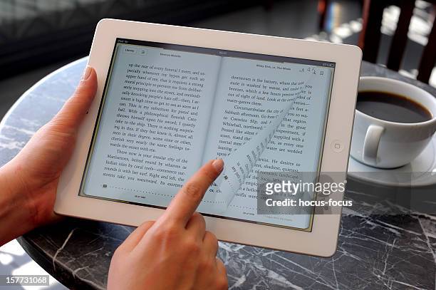 reading e-book with ipad 3 - e reader stock pictures, royalty-free photos & images