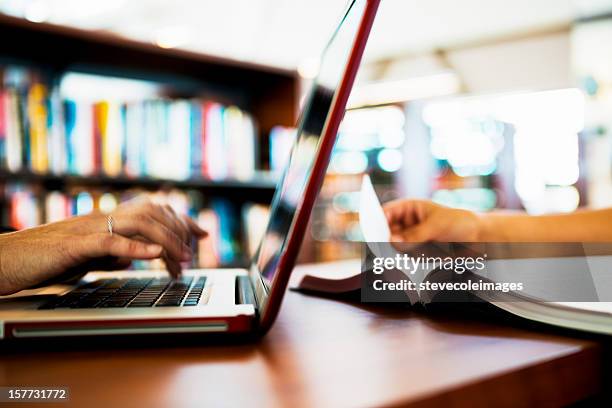 laptop computer and book on table - school book stock pictures, royalty-free photos & images