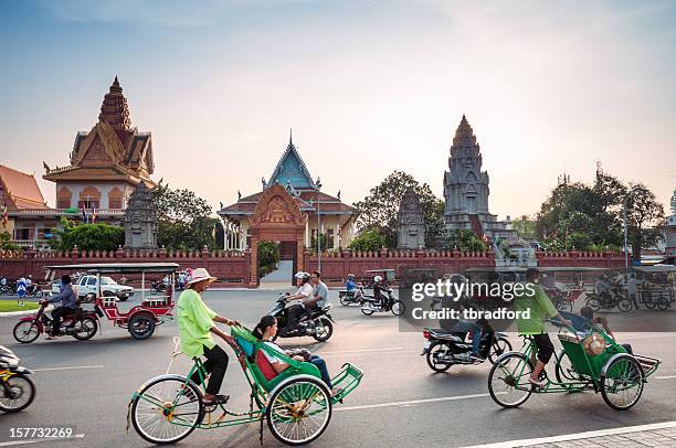 busy traffic outside wat ounalom at sunset in phnom penh - cambodian stock pictures, royalty-free photos & images