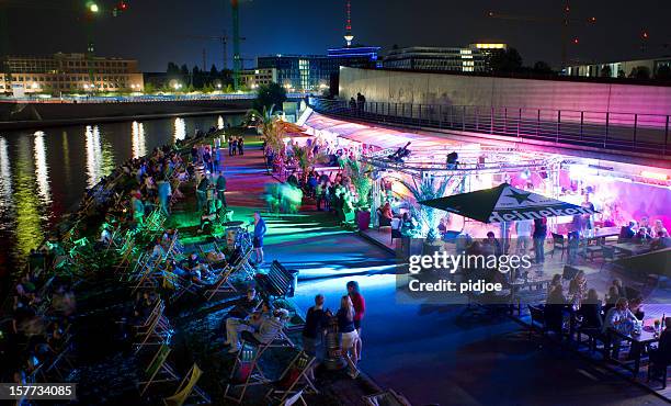 people relaxing at strand bar near spree river berlin germany - berlin nightlife stock pictures, royalty-free photos & images