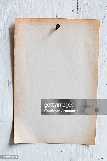 old paper nailed to a weathered wooden board. - pinning stock pictures, royalty-free photos & images