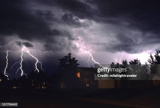four lightning strikes over houses and trees in denver - lightning home stock pictures, royalty-free photos & images