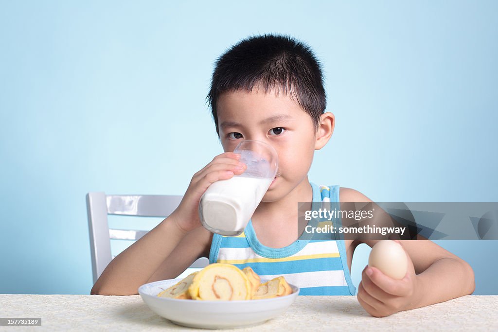 Young boy eating breakfast before heading to school