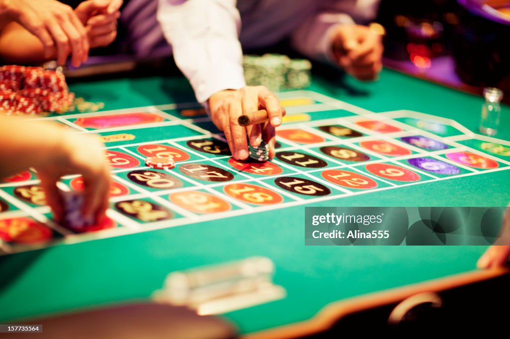 Hand of gambler making a bet at roulette table