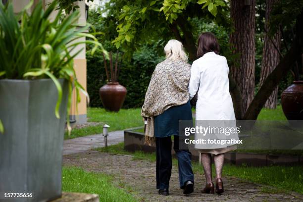 senior mujer recibe ayuda del personal de enfermería para caminar - gemeinsam gehen fotografías e imágenes de stock