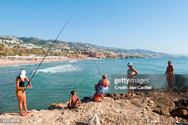 women fishing at beach in byblos, lebanon - byblos lebanon stock pictures, royalty-free photos & images