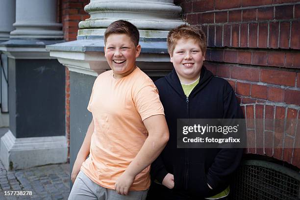 friendship: two overweight teenage boys in front of their school - fat redhead stock pictures, royalty-free photos & images