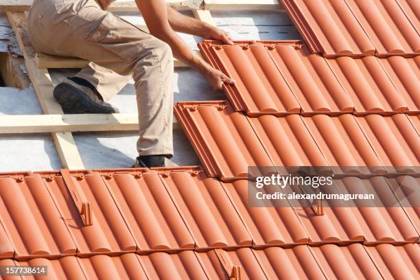 man working on the roof - roof tile stock pictures, royalty-free photos & images
