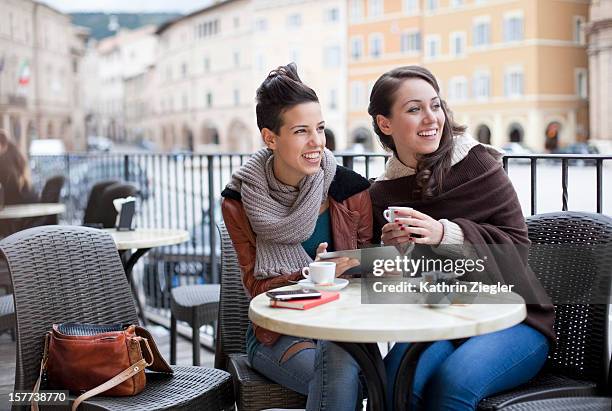 two teenage girls at a café, using digital tablet - italian cafe culture stock pictures, royalty-free photos & images