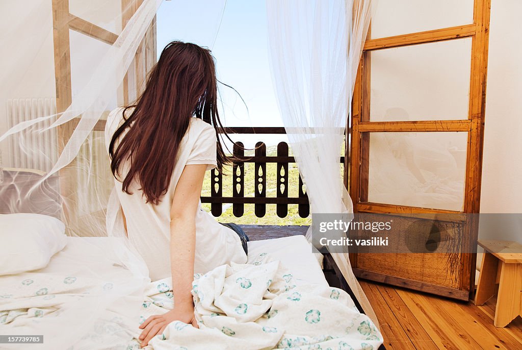 Woman getting out of bed and embracing a brand new day