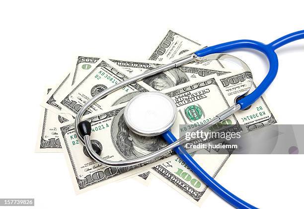 stethoscope on us dollars isolated on white background - medicaid stockfoto's en -beelden