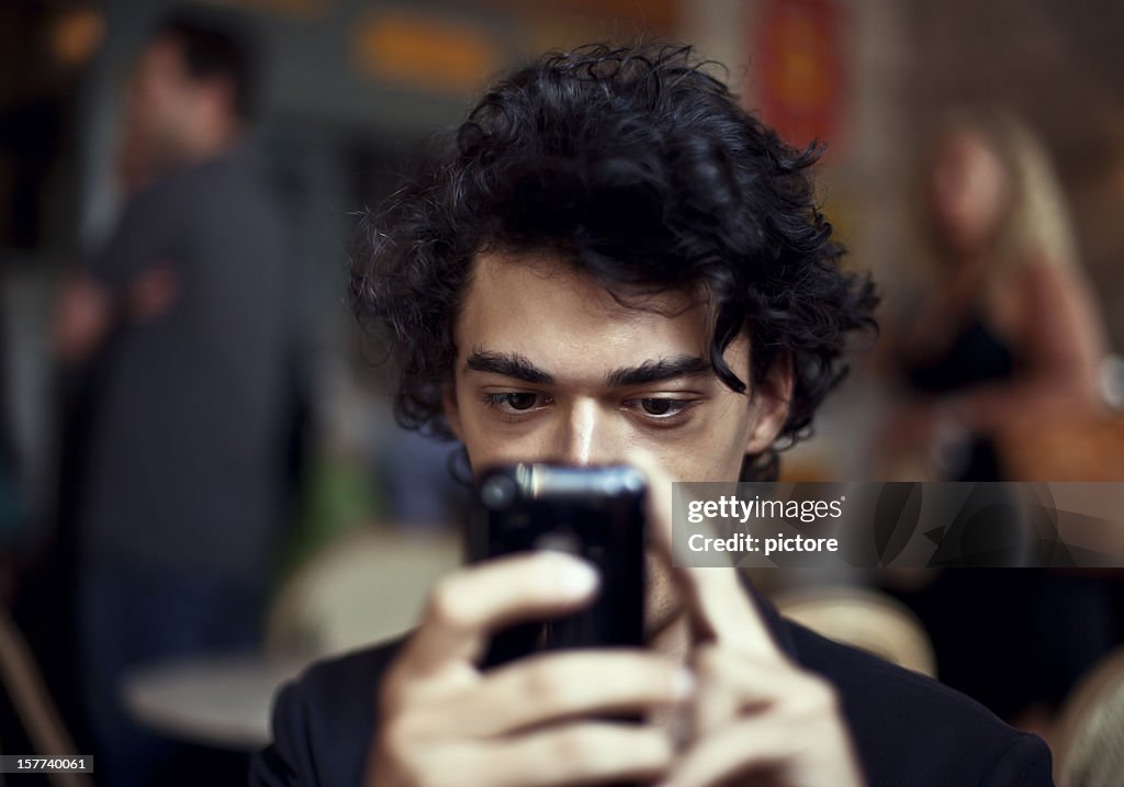 Young man communicating with his smartphone