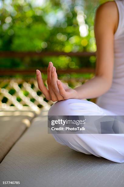 frau sitzt mit yoga lotus position - frau macht yoga stock-fotos und bilder