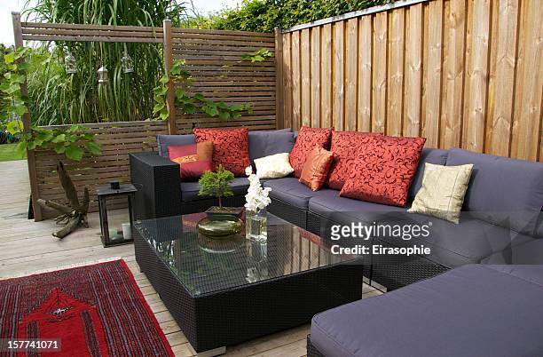contemporary patio with large wicker sofa. garden design - fence stockfoto's en -beelden