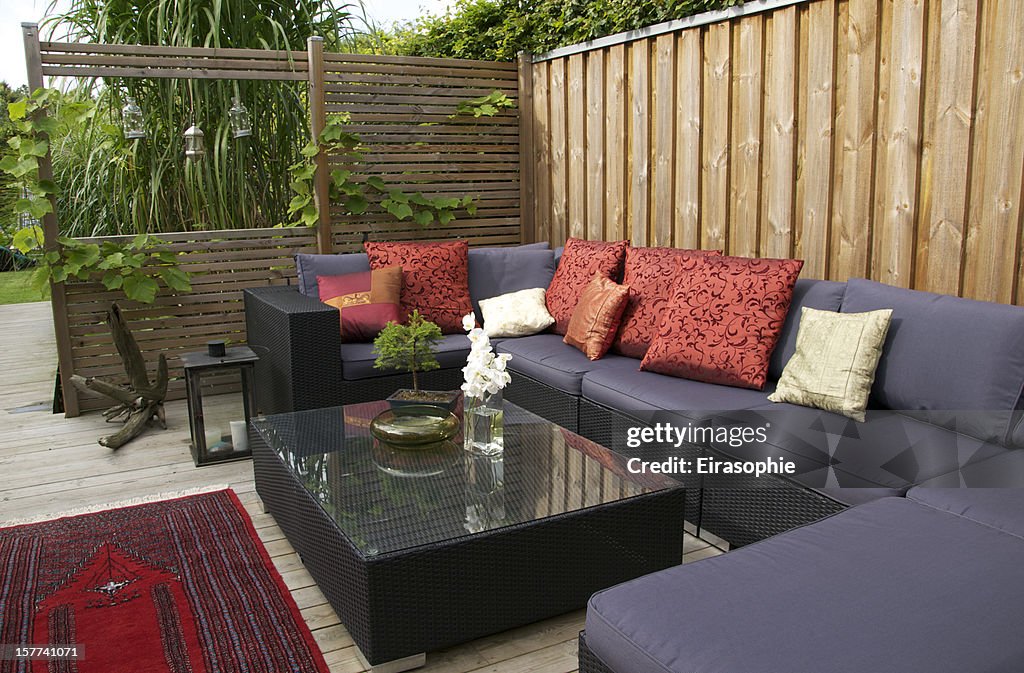 Contemporary patio with large wicker sofa. Garden design