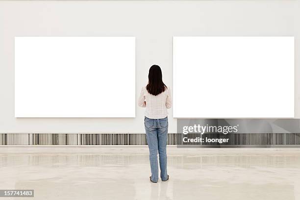 eine frau, die auf weißen rahmen in kunstgalerie - one man only photos stock-fotos und bilder