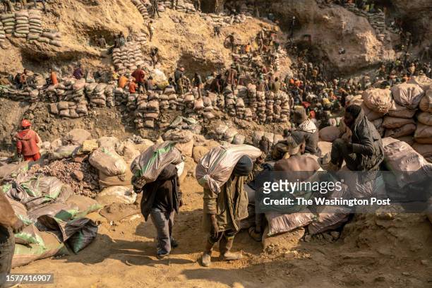 Miners carry bags of ore in the copper-cobalt Shabara artisanal mine near the town of Kolwezi, Lualaba, Democratic Republic of Congo, June 20, 2023.