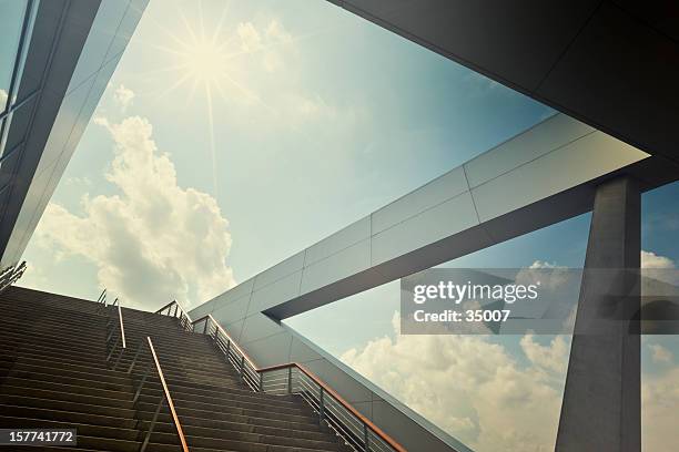 a stairway leading up to blue sky with sun over light cloud - vooruit kijken stockfoto's en -beelden
