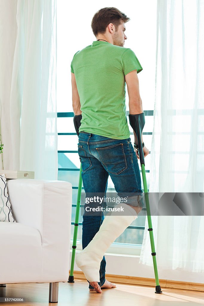 Young man with broken leg at home